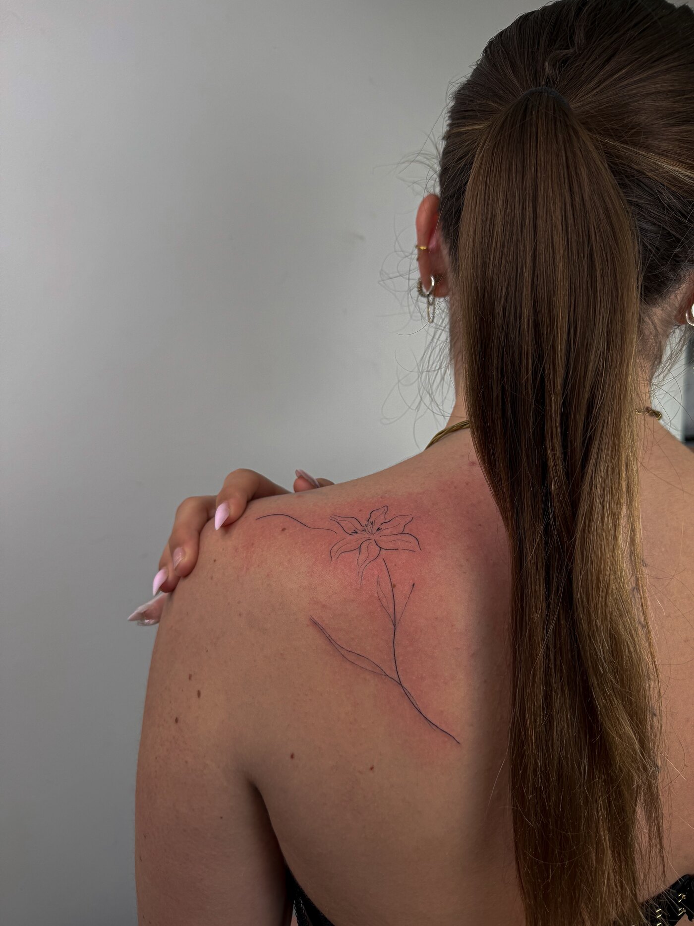 Tatouage floral fineline sur l'épaule